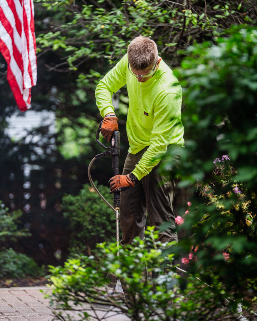 HLM crew member pruning a flowering shrub